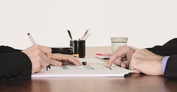 Employer and employee agreeing to something by desk